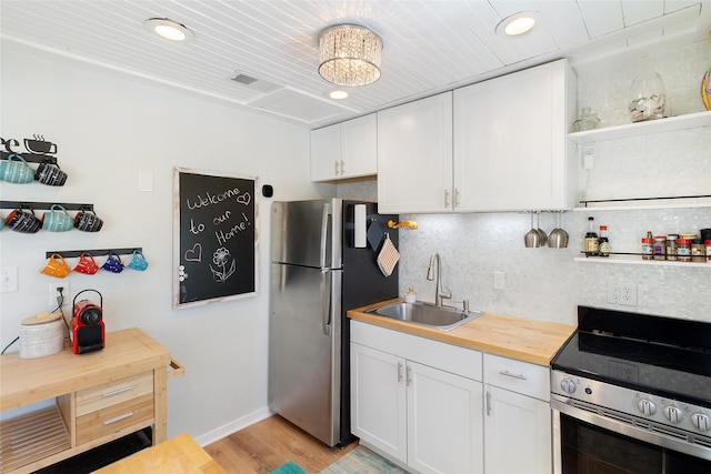 1010 Fort Velasco Dr, Surfside Beach, TX 77541 - kitchen with stainless steel appliances, a sink, wood counters, white cabinetry, and recessed lighting
