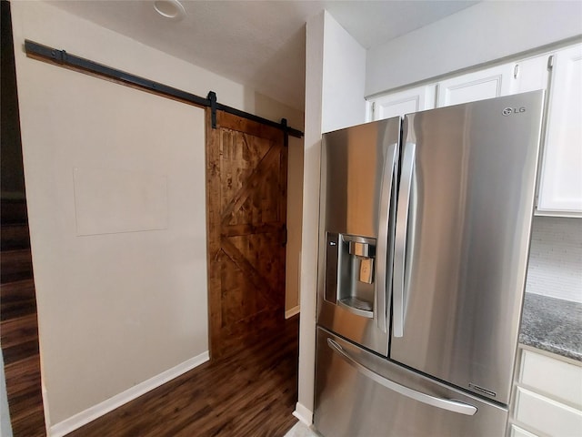 2356 Gemini St, Houston, TX 77058 - kitchen featuring stainless steel refrigerator with ice dispenser, dark wood finished floors, white cabinetry, dark stone countertops, and a barn door