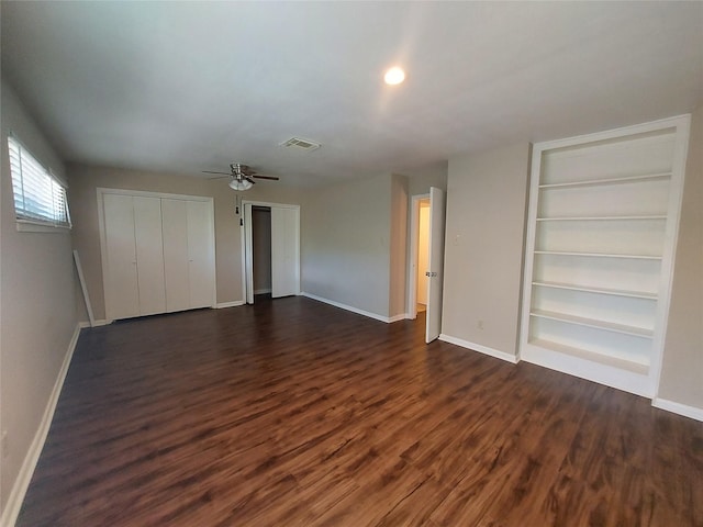 2356 Gemini St, Houston, TX 77058 - unfurnished bedroom featuring multiple closets, baseboards, dark wood finished floors, and a ceiling fan