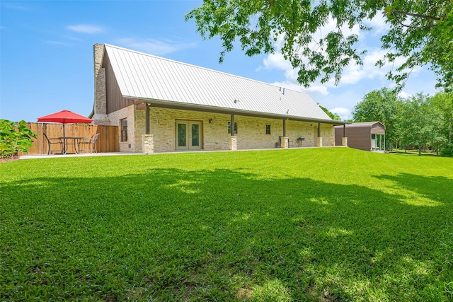 16325 Senkel Rd, East Bernard, TX 77435 - back of property featuring french doors, stone siding, metal roof, a chimney, and a standing seam roof