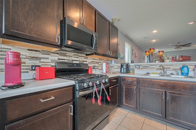 10027 Yanet Grove Ln, Houston, TX 77044 - kitchen with appliances with stainless steel finishes, a sink, ceiling fan, light tile patterned flooring, and decorative backsplash