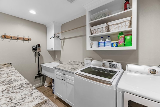 4439 W Bayshore Rd, Anahuac, TX 77514 - laundry area with washer and dryer, cabinet space, and baseboards