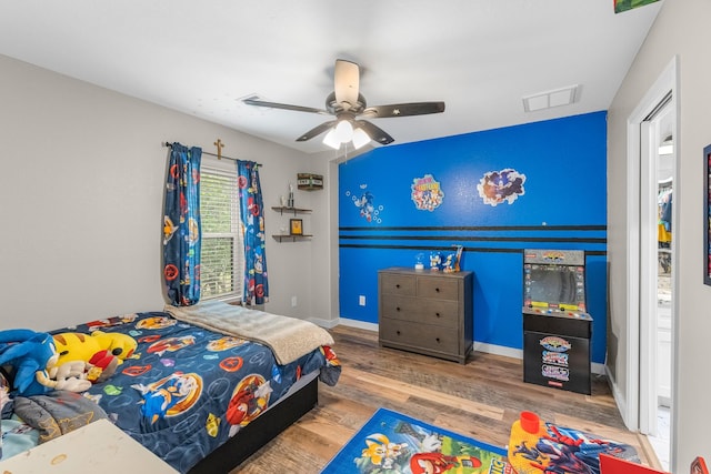 4439 W Bayshore Rd, Anahuac, TX 77514 - bedroom featuring wood finished floors, baseboards, and a ceiling fan