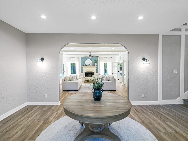20647 Laurel Lock Dr, Katy, TX 77450 - entrance foyer featuring a textured wall, arched walkways, wood finished floors, baseboards, and a fireplace