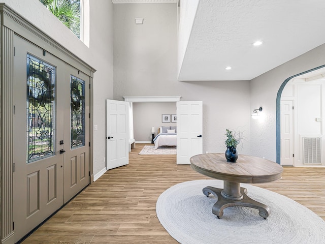 20647 Laurel Lock Dr, Katy, TX 77450 - foyer with baseboards, light wood-type flooring, arched walkways, recessed lighting, and a high ceiling