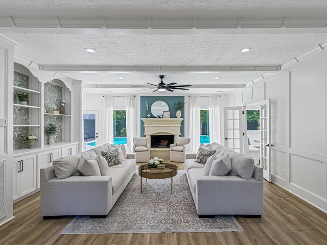20647 Laurel Lock Dr, Katy, TX 77450 - living area with wood finished floors, plenty of natural light, a ceiling fan, a decorative wall, and a textured ceiling