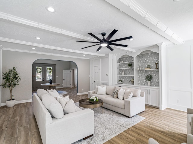20647 Laurel Lock Dr, Katy, TX 77450 - living area with arched walkways, a textured ceiling, light wood finished floors, a ceiling fan, and baseboards