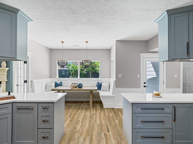 20647 Laurel Lock Dr, Katy, TX 77450 - kitchen featuring light countertops, gray cabinets, light wood-style floors, breakfast area, and wainscoting