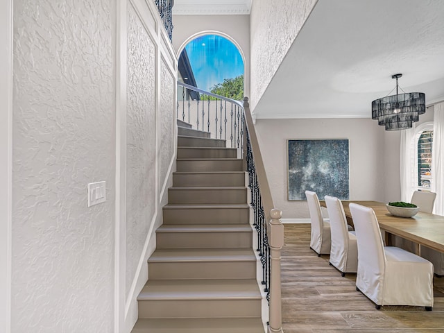 20647 Laurel Lock Dr, Katy, TX 77450 - staircase featuring a textured wall, crown molding, a chandelier, wood finished floors, and plenty of natural light