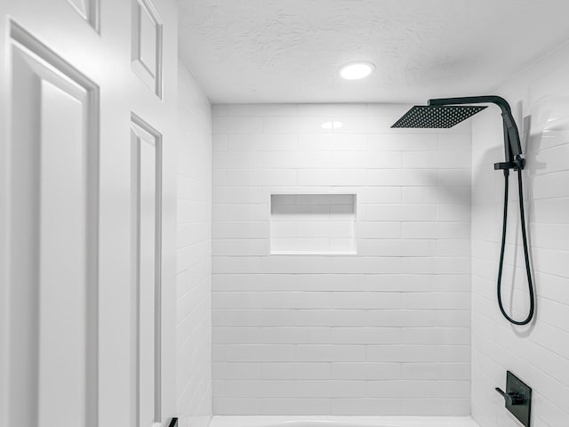 20647 Laurel Lock Dr, Katy, TX 77450 - bathroom with a tile shower, a textured ceiling, and recessed lighting