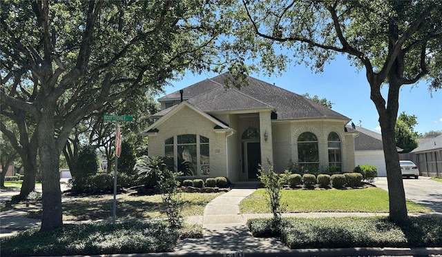 2331 Scottsdale Ct, League City, TX 77573 - french country style house with brick siding, driveway, a front lawn, roof with shingles, and an attached garage