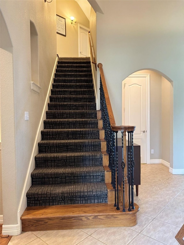 2331 Scottsdale Ct, League City, TX 77573 - stairway featuring arched walkways, tile patterned flooring, and baseboards