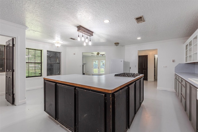 15329 Cedar St, Santa Fe, TX 77517 - kitchen featuring crown molding, a kitchen island, stainless steel gas stovetop, concrete flooring, and ceiling fan