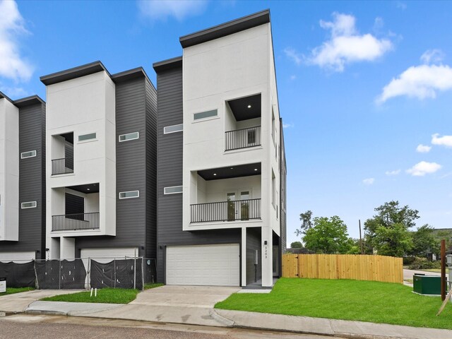 5203 San Juan St, Houston, TX 77020 - view of front facade featuring a garage, a balcony, and concrete driveway