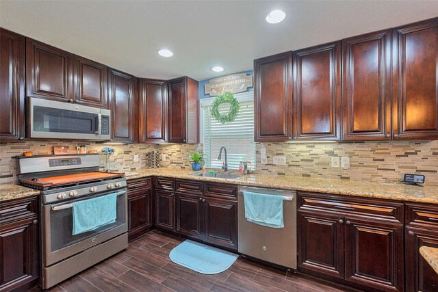 3207 Pheasant Trail Dr, Sugar Land, TX 77498 - kitchen with stainless steel appliances, a sink, decorative backsplash, light stone counters, and recessed lighting
