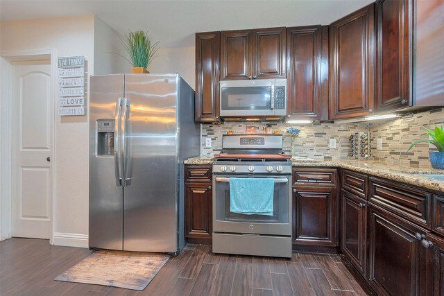 3207 Pheasant Trail Dr, Sugar Land, TX 77498 - kitchen featuring appliances with stainless steel finishes, dark wood-style flooring, tasteful backsplash, and light stone counters