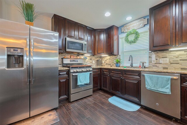 3207 Pheasant Trail Dr, Sugar Land, TX 77498 - kitchen with appliances with stainless steel finishes, a sink, decorative backsplash, dark brown cabinetry, and recessed lighting