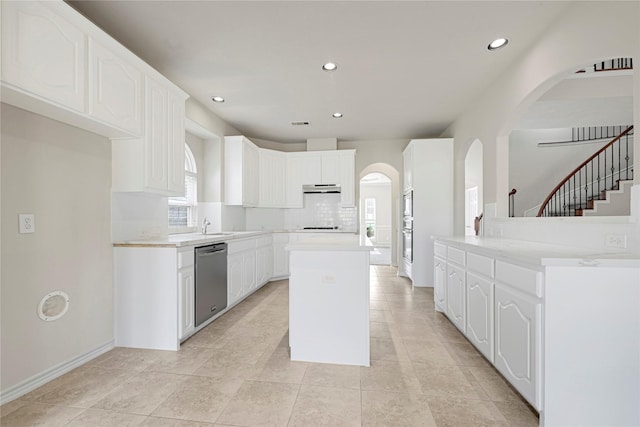 2108 Asbury Ct, Pearland, TX 77581 - kitchen with stainless steel dishwasher, arched walkways, under cabinet range hood, plenty of natural light, and recessed lighting
