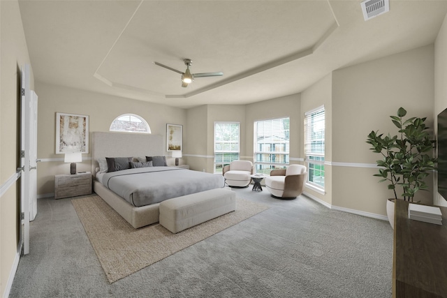 2108 Asbury Ct, Pearland, TX 77581 - carpeted bedroom featuring a tray ceiling, multiple windows, a ceiling fan, and baseboards