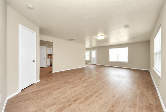 5043 Canyon Blanco Dr, Houston, TX 77045 - spare room featuring healthy amount of natural light, light wood-type flooring, and baseboards