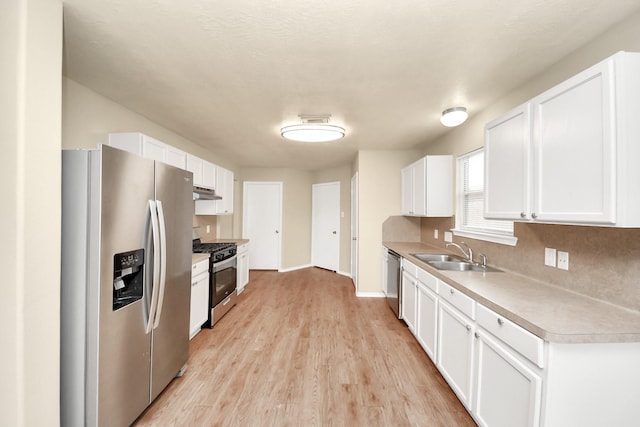 5043 Canyon Blanco Dr, Houston, TX 77045 - kitchen with appliances with stainless steel finishes, a sink, under cabinet range hood, white cabinets, and light countertops