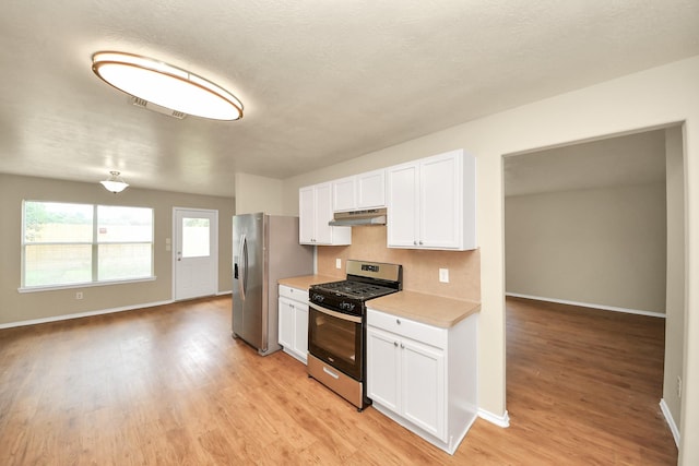 5043 Canyon Blanco Dr, Houston, TX 77045 - kitchen with appliances with stainless steel finishes, under cabinet range hood, light countertops, and baseboards