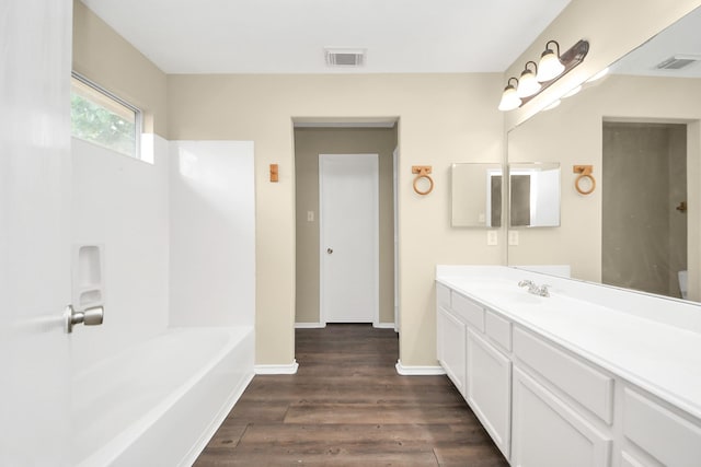 5043 Canyon Blanco Dr, Houston, TX 77045 - bathroom featuring wood finished floors, vanity, a tub, and baseboards