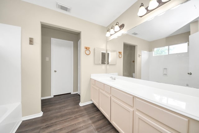 5043 Canyon Blanco Dr, Houston, TX 77045 - full bath featuring wood finished floors, vanity, a tub to relax in, and baseboards