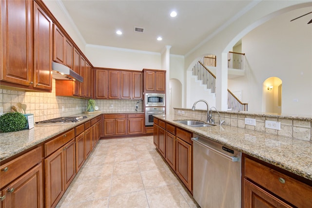 28015 Heritage Stream Dr, Katy, TX 77494 - kitchen with stainless steel appliances, under cabinet range hood, a sink, ornamental molding, and tasteful backsplash