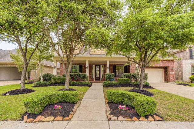 28015 Heritage Stream Dr, Katy, TX 77494 - view of front facade with brick siding, concrete driveway, covered porch, and a front yard