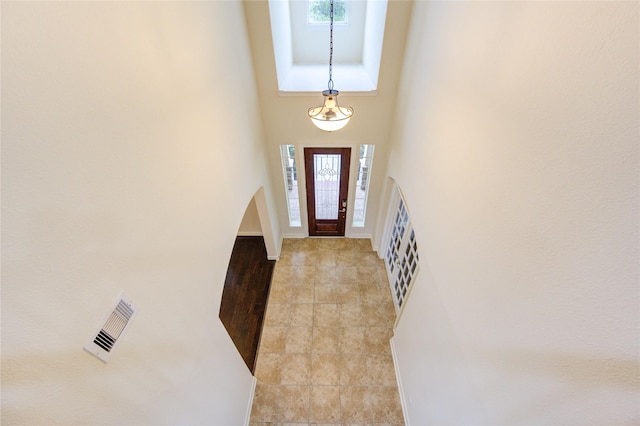 28015 Heritage Stream Dr, Katy, TX 77494 - entryway featuring a high ceiling, arched walkways, light tile patterned flooring, and baseboards