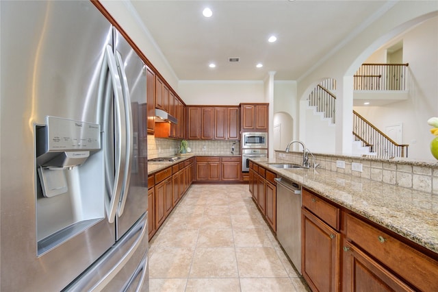 28015 Heritage Stream Dr, Katy, TX 77494 - kitchen featuring stainless steel appliances, a sink, decorative backsplash, ornamental molding, and light stone countertops