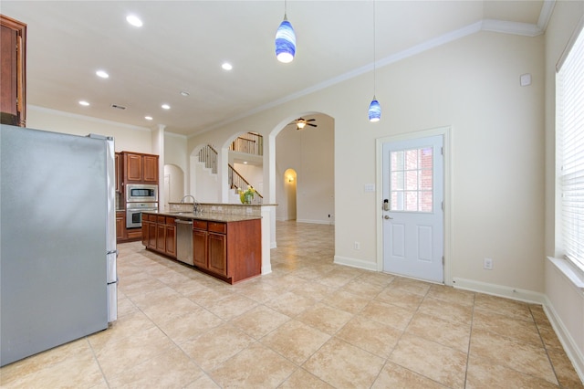28015 Heritage Stream Dr, Katy, TX 77494 - kitchen with stainless steel appliances, arched walkways, ornamental molding, recessed lighting, and brown cabinets