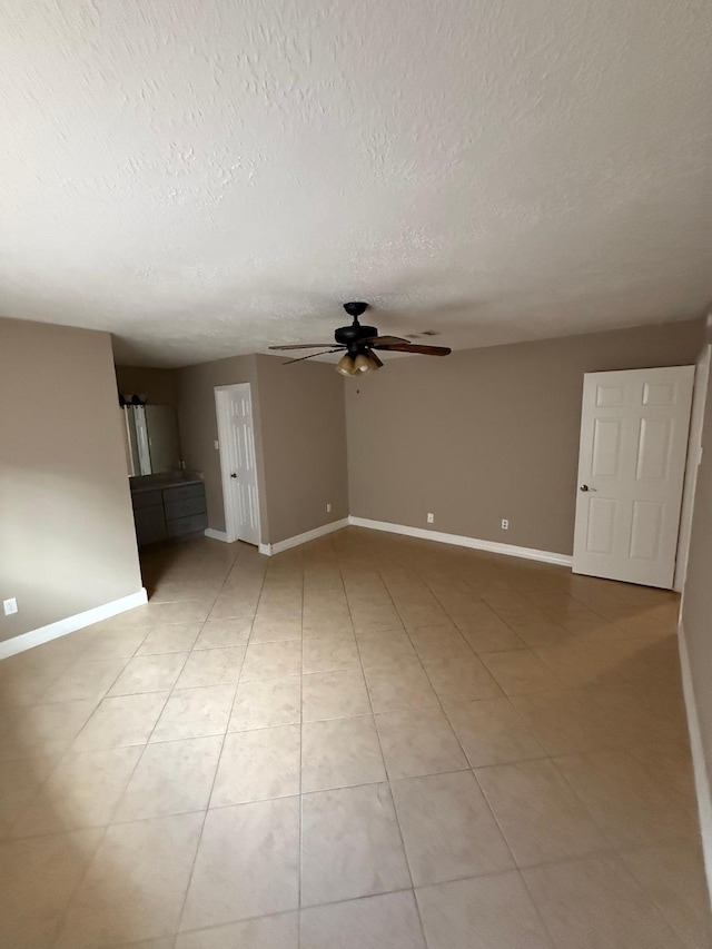 2614 Sicklepod Dr, Houston, TX 77084 - unfurnished living room featuring a ceiling fan, a textured ceiling, baseboards, and light tile patterned floors