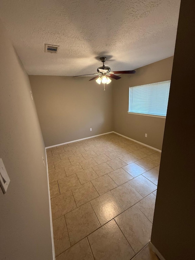 2614 Sicklepod Dr, Houston, TX 77084 - tiled spare room featuring a ceiling fan, a textured ceiling, and baseboards