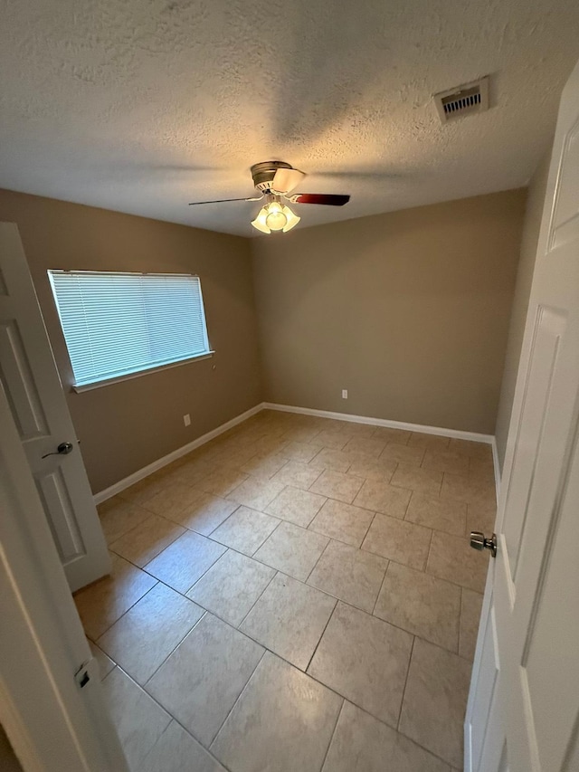 2614 Sicklepod Dr, Houston, TX 77084 - empty room with a textured ceiling, a ceiling fan, light tile patterned floors, and baseboards