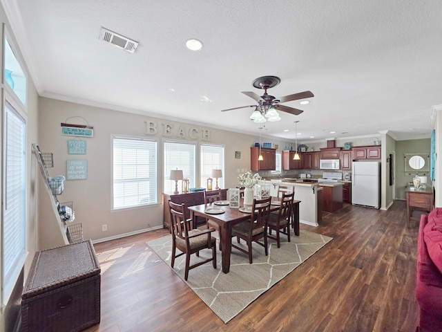 936 Surf Rd, Crystal Beach, TX 77650 - dining room with crown molding, plenty of natural light, ceiling fan, dark wood finished floors, and recessed lighting