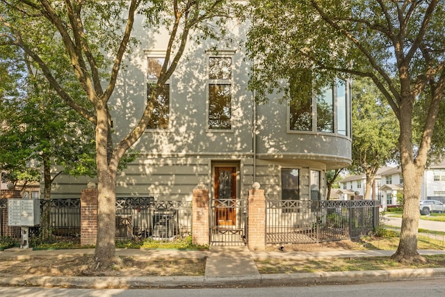 townhome / multi-family property with a fenced front yard and a gate