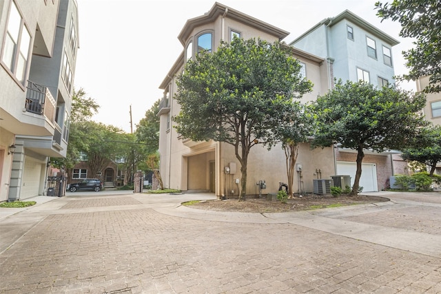 view of building exterior featuring decorative driveway and cooling unit