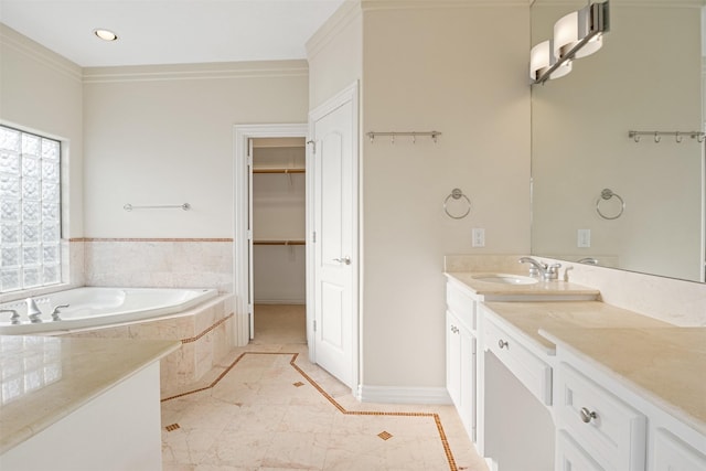 full bath with a spacious closet, vanity, a garden tub, baseboards, and recessed lighting