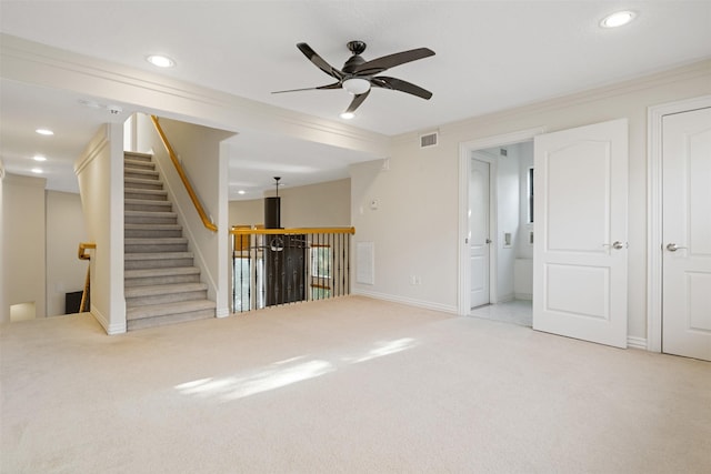unfurnished living room featuring light carpet, ceiling fan, ornamental molding, recessed lighting, and baseboards
