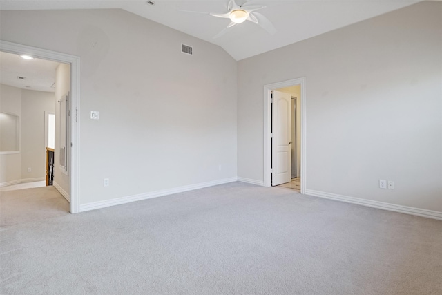 empty room featuring vaulted ceiling, ceiling fan, light carpet, and baseboards