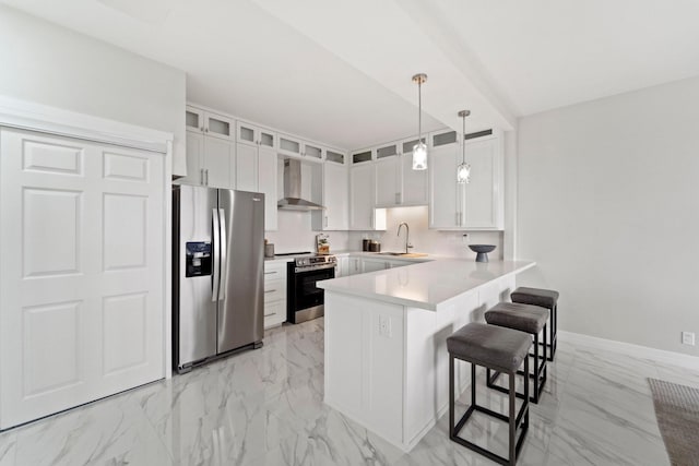 651 Bering Dr Unit 1406, Houston, TX 77057 - kitchen featuring stainless steel appliances, wall chimney exhaust hood, a sink, light marble finish floors, and a peninsula