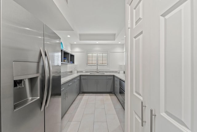651 Bering Dr Unit 1406, Houston, TX 77057 - kitchen featuring stainless steel appliances, gray cabinets, a tray ceiling, light tile patterned flooring, and recessed lighting