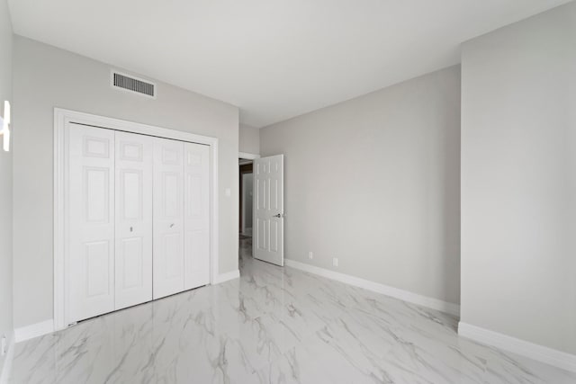 651 Bering Dr Unit 1406, Houston, TX 77057 - unfurnished bedroom featuring light marble finish floors, a closet, and baseboards