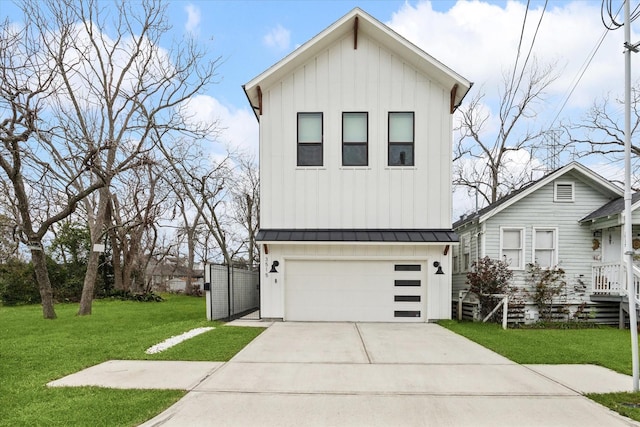 view of front of house with board and batten siding, an attached garage, driveway, a front yard, and a standing seam roof