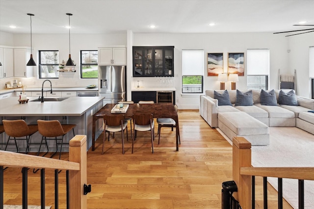 living room featuring light wood-style flooring, recessed lighting, and beverage cooler