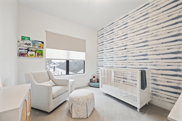 carpeted bedroom featuring a nursery area