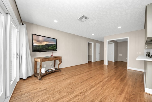 1815 Tannehill Dr, Houston, TX 77008 - unfurnished living room featuring light wood-type flooring, a textured ceiling, and recessed lighting