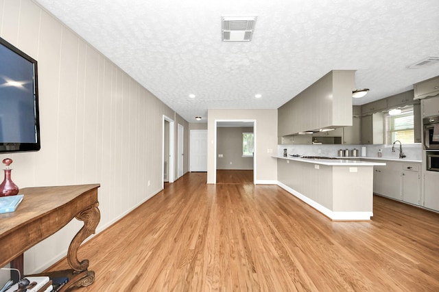1815 Tannehill Dr, Houston, TX 77008 - kitchen with gray cabinetry, light wood-style flooring, light countertops, plenty of natural light, and a textured ceiling